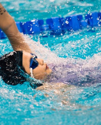 zwemmer met duikbril in water op rug