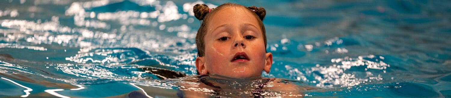 meisje met twee knotjes zwemt schoolslag