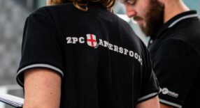 Foto van een trainer die een shirt draagt met op de rug het logo van ZPC Amersfoort