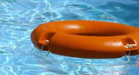 rode reddingsboei drijft op blauw zwembadwater